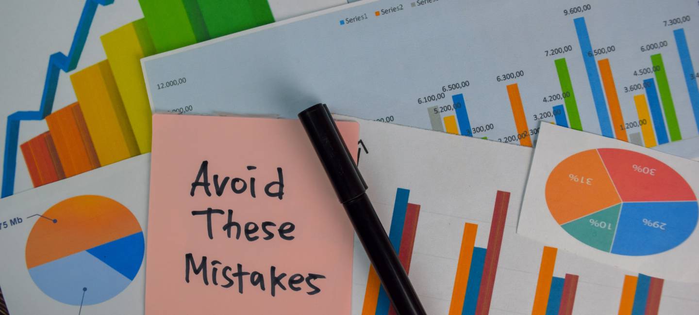 Avoid These Mistakes write on sticky notes isolated on Wooden Table. 