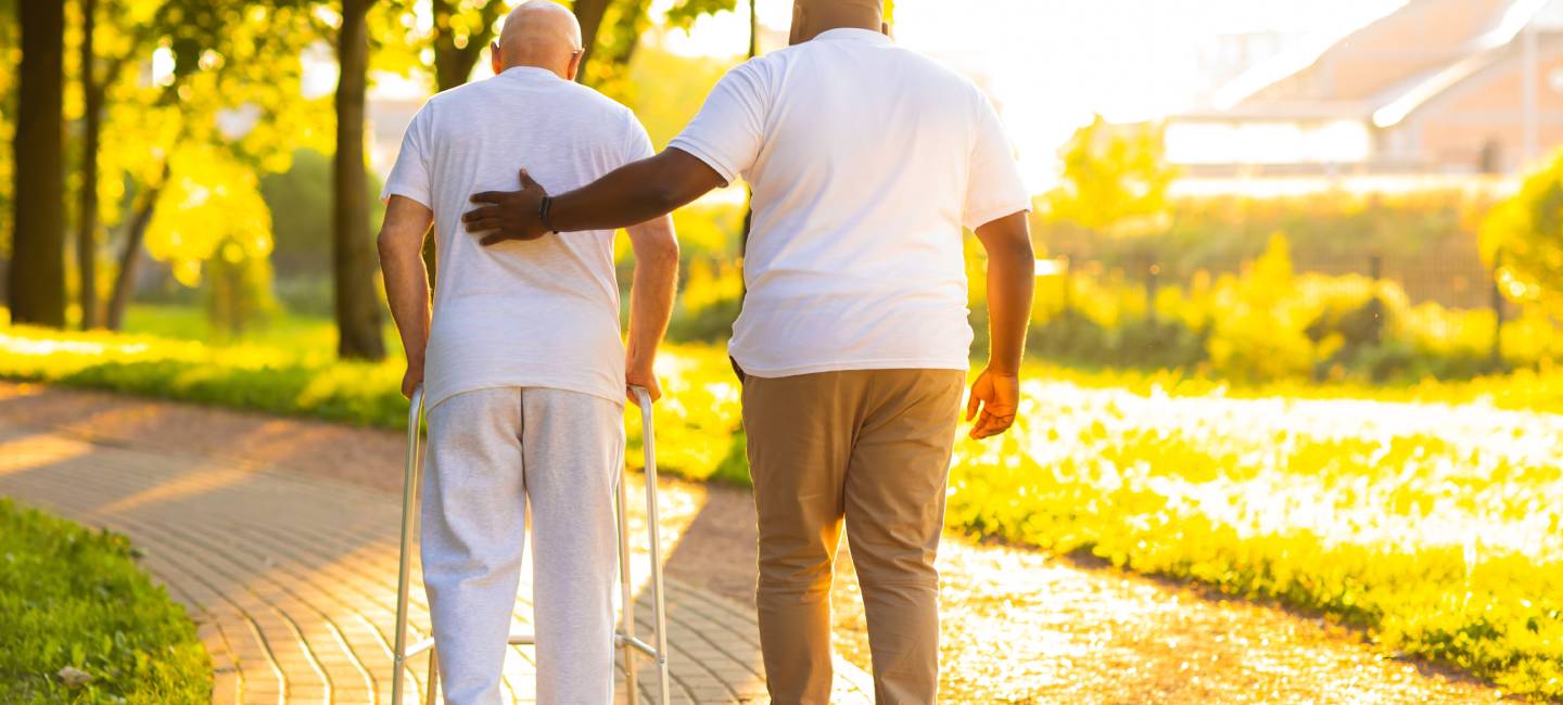 Professional nurse and patient walking outdoor at sunset