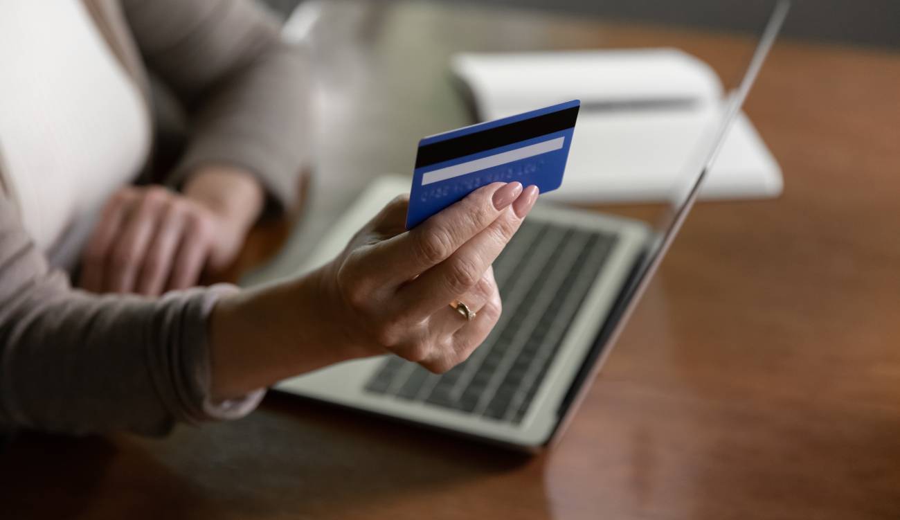 person buyer shopping online on laptop with credit debit card. Mature modern woman client make payment buy on web on computer with secure banking application on device.