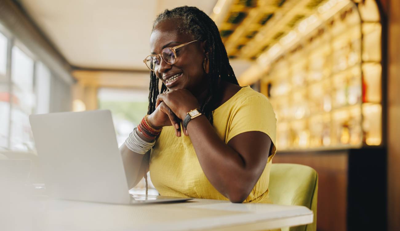 Black businesswoman having a video call with her colleagues while working in a cafe.