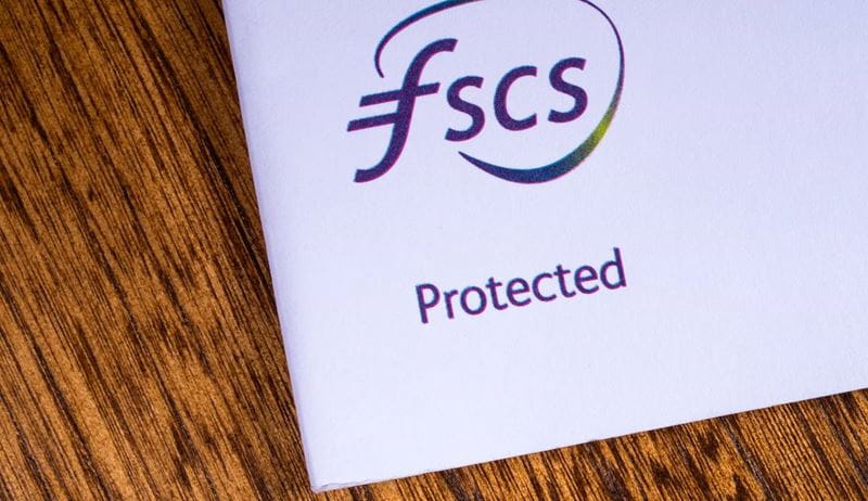 A close-up of the FSCS - Financial Services Compensation Scheme logo, pictured on an information leaflet.