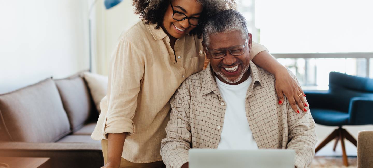 Affectionate senior couple enjoying quality time at home while using a laptop.