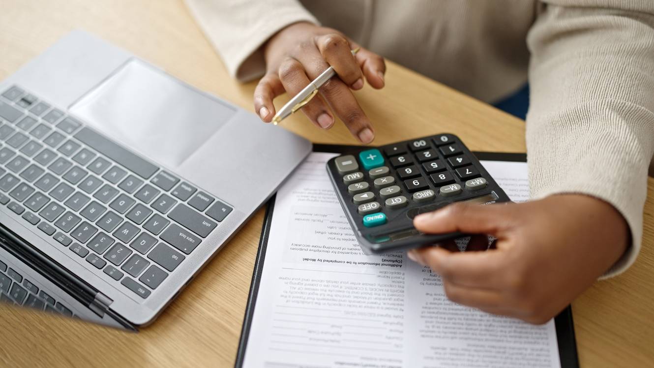 African american woman business worker using laptop and calculator at office