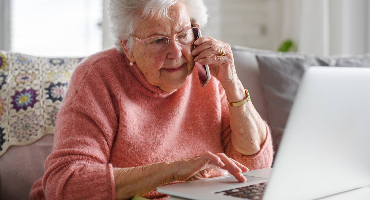 Senior woman using the a laptop and on the phone 