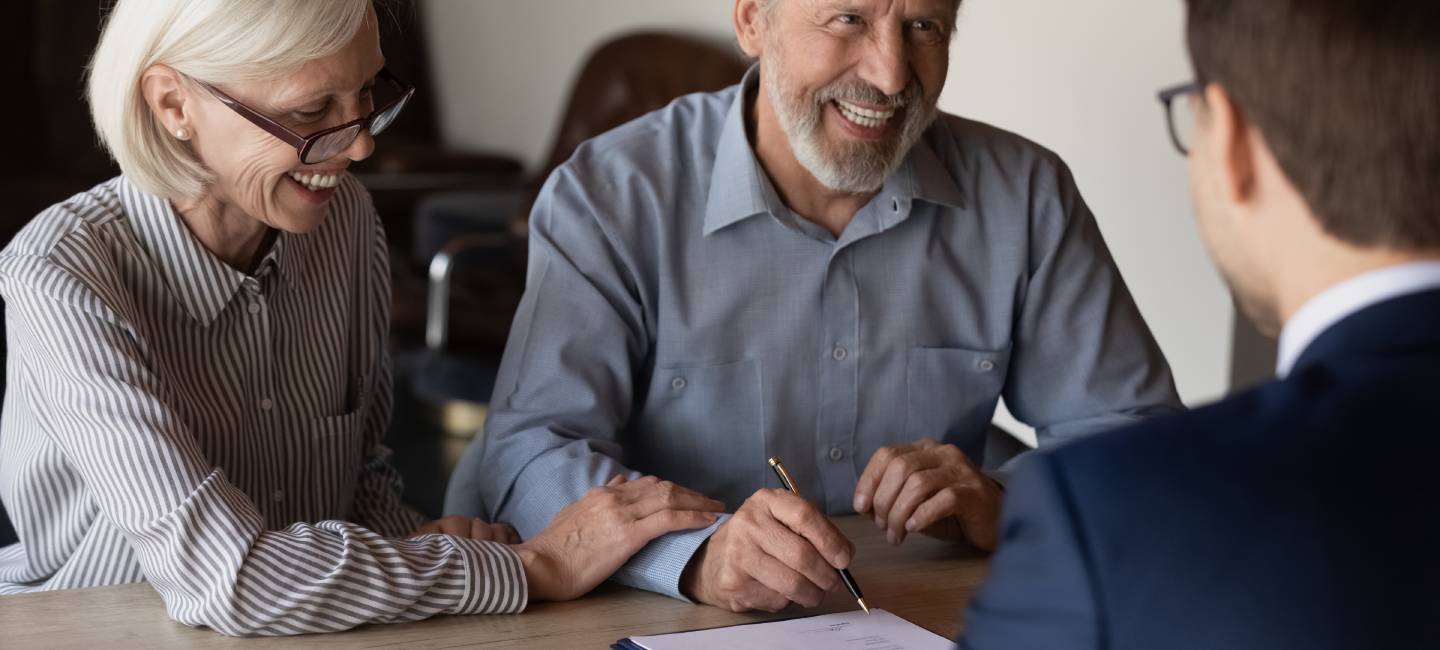 Happy mature family couple of clients consulting financial advisor