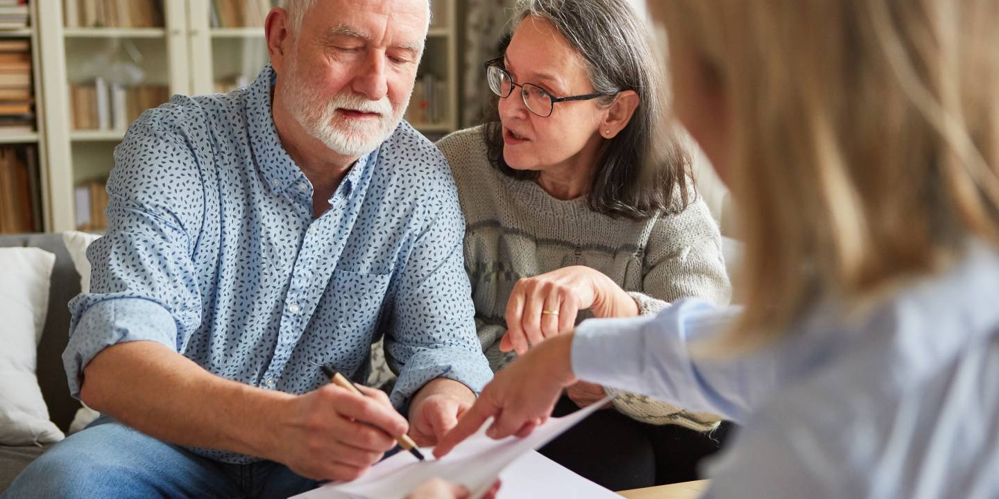 Seniors sign a contract or power of attorney at home after a consultation
