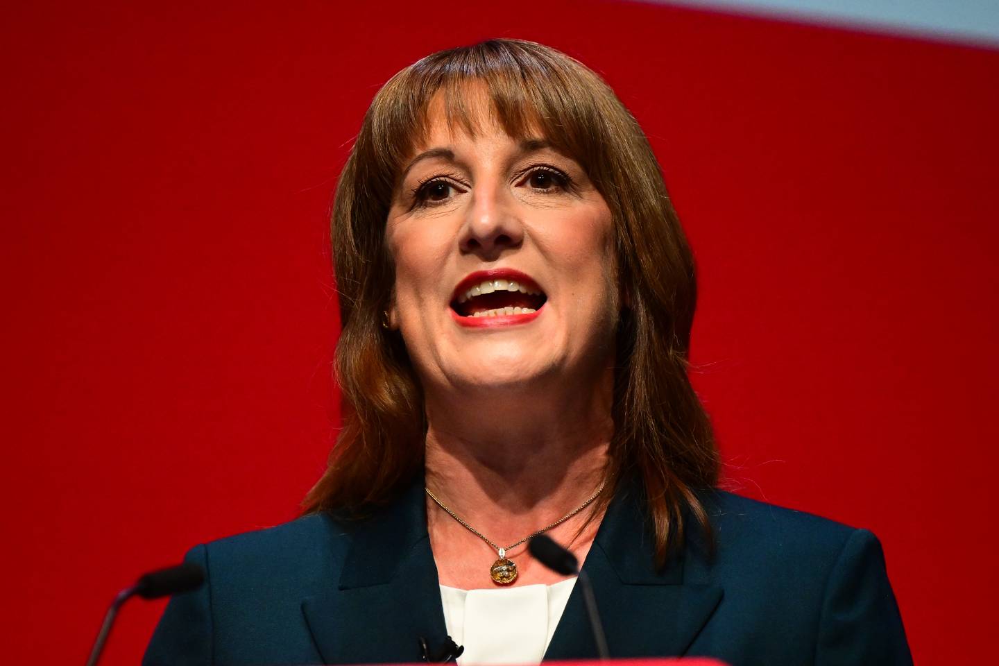 Rachel reeves in front of a red background