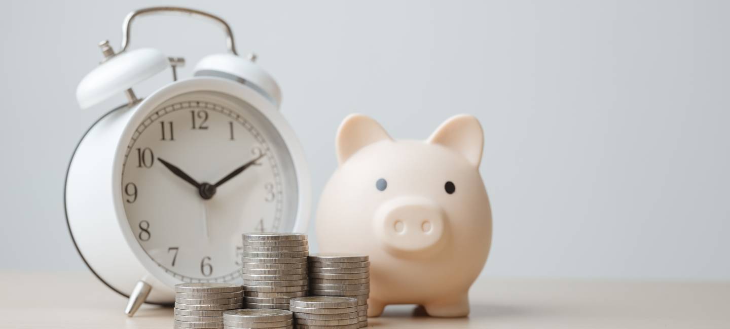 Piggy bank, alarm clock, and stacked coins symbolizing bill reminders,