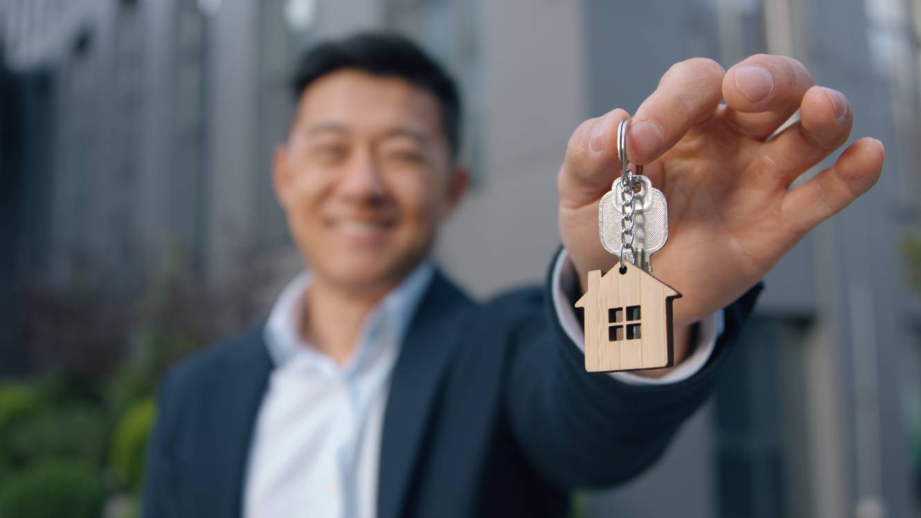 Happy business man showing bunch of keys 
