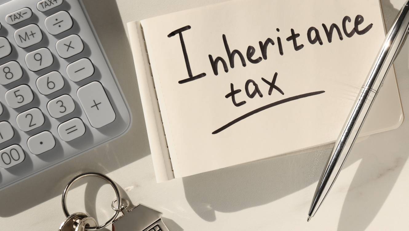 Notepad with phrase Inheritance Tax, calculator and keys with house shaped key chain on white table