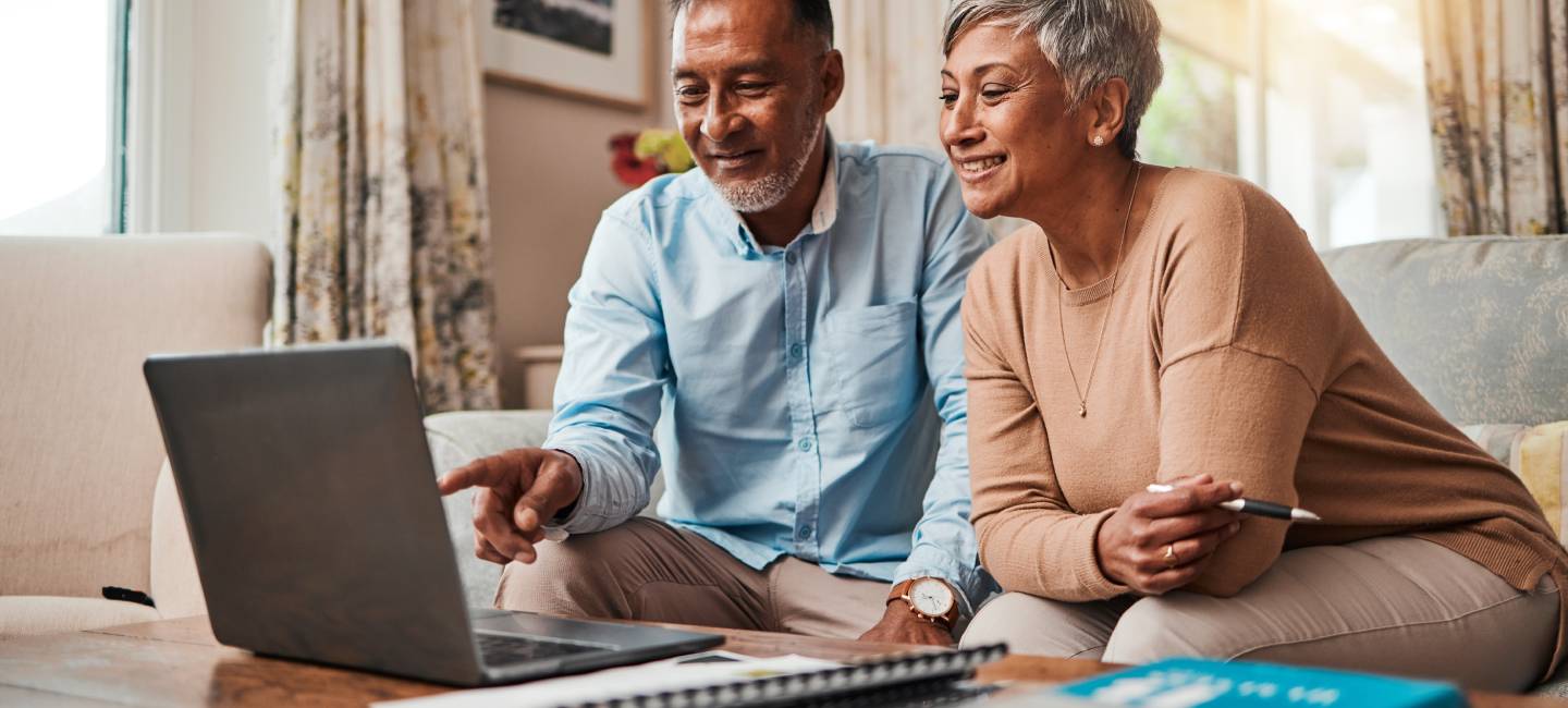 Mature couple reading information on computer for pension savings