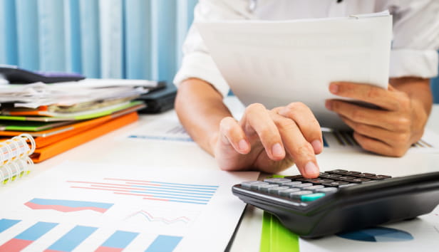 A person typing in to a calculator