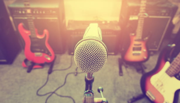 A microphone and three guitars