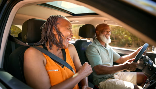 Senior Couple Enjoying Summer Day Trip Out Driving In Car Together