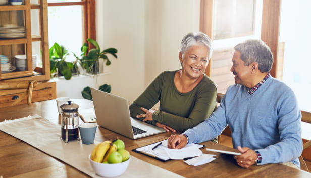 Finance, laptop and happy senior couple with bills, paperwork and documents for life insurance. Retirement, pension and elderly man and woman on computer for mortgage payment, investment and budget