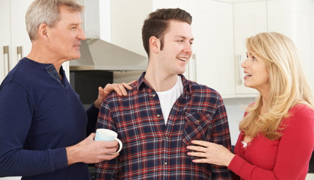 Portrait Of Family With Adult Son At Home.