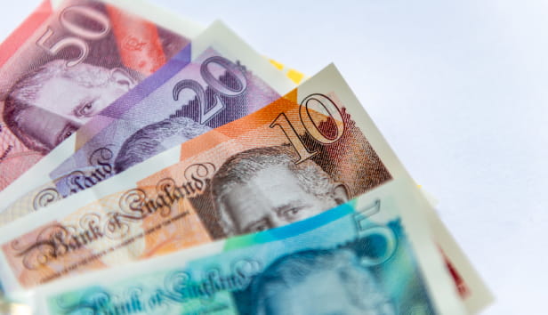 Updated Pound Sterling bank notes with the King's portrait isolated in a white background.