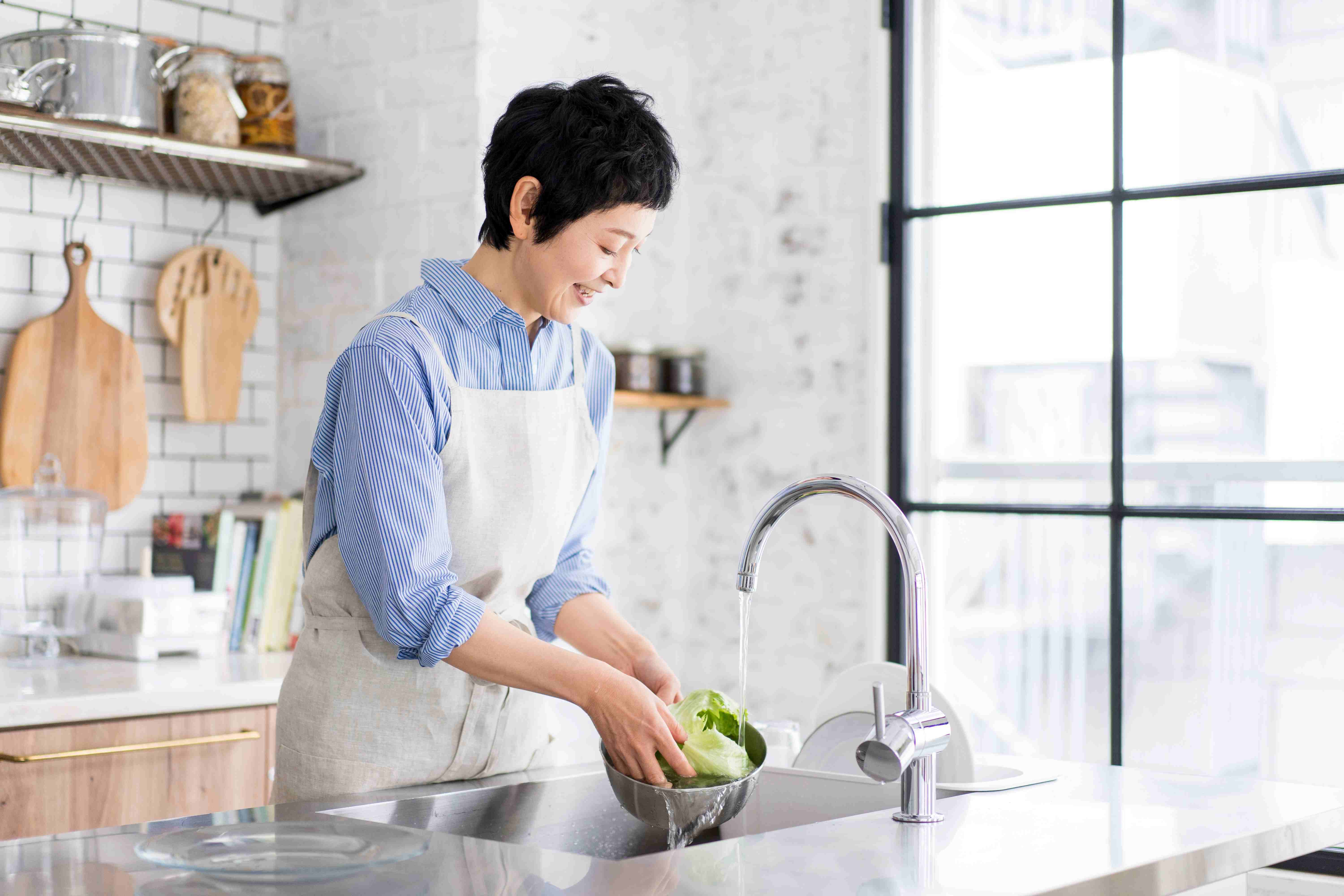 Woman washing salad leaves 