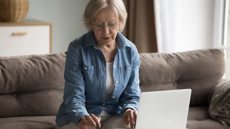 A woman sat in front of an open laptop