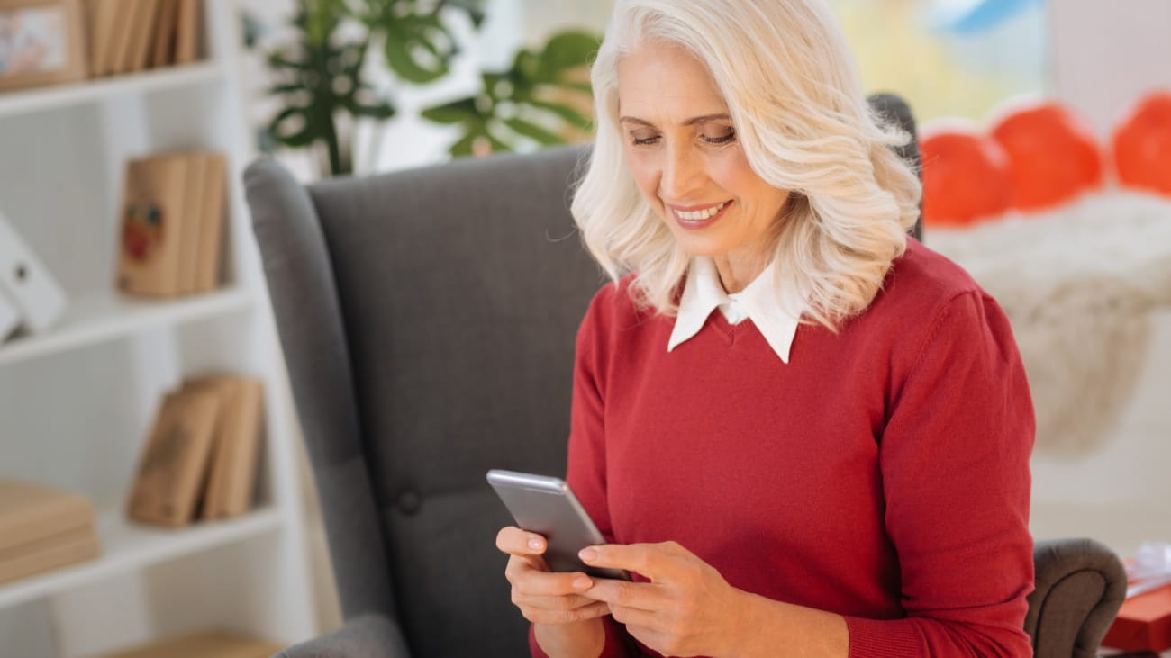 A smiley lady sat looking at her mobile phone
