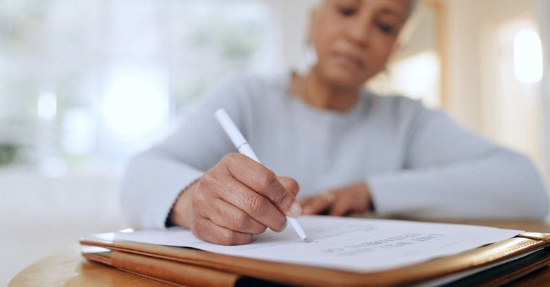 A woman sat at a desk signing an official document