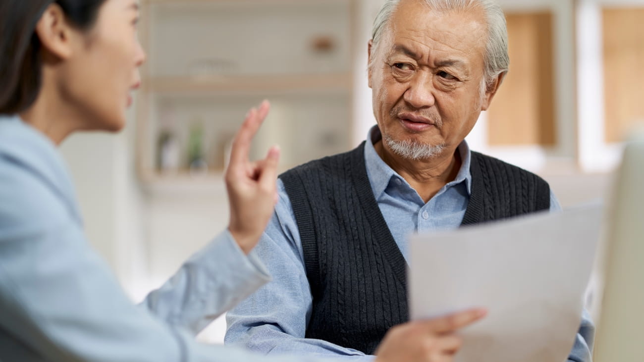 Two people looking worried and holding lots of paperwork