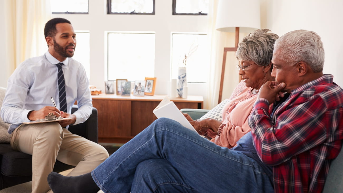 Senior Couple Meeting With Male Financial Advisor At Home