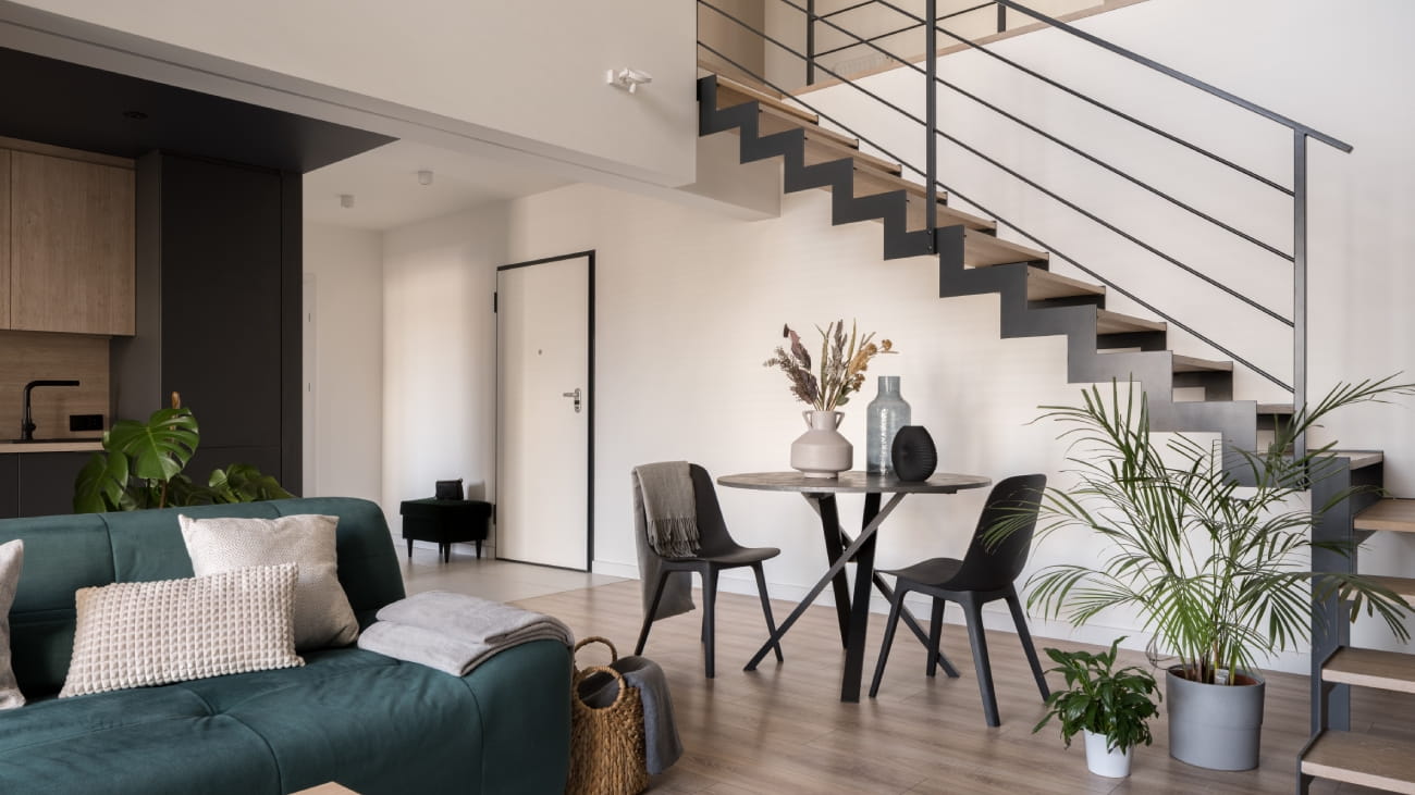 Modern, two-floor apartment with stylish living room with dining table, open to kitchen and stairs to next floor