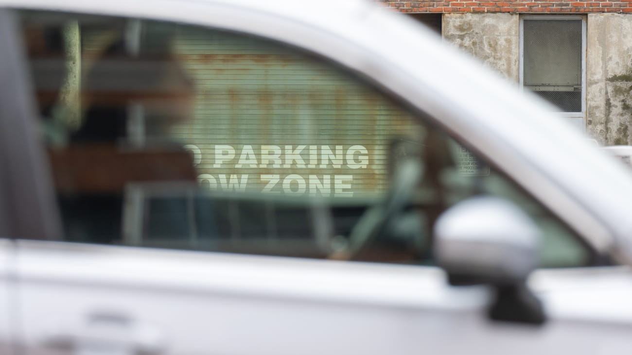 Car passing a no parking sign