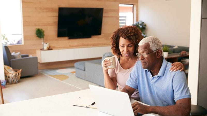 Senior African American Couple Using Laptop To Check Finances At Home