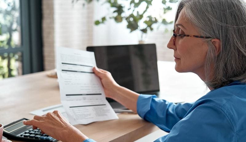 Senior mature business woman managing account finances, calculating money budget tax, planning banking .