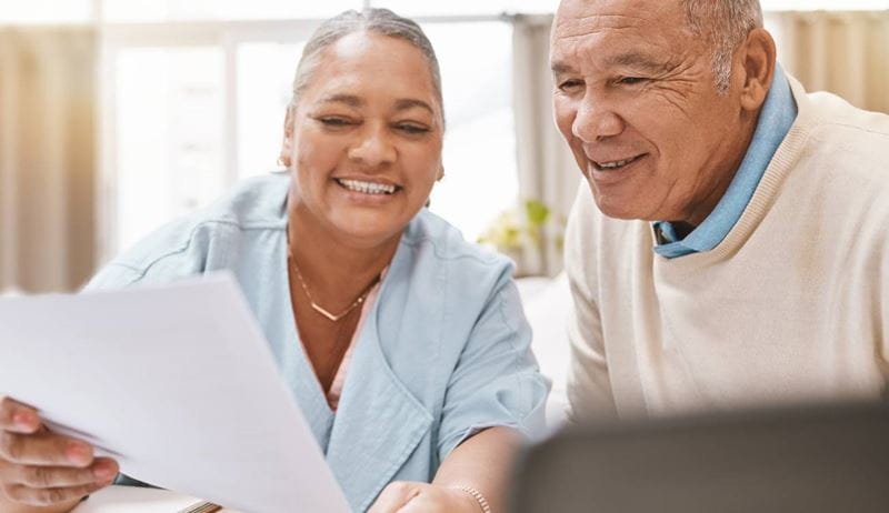 mature black couple, reviewing paperwork and laptop for planning, budget or taxes