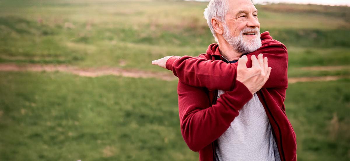 A man in the foreground stretching before exercise