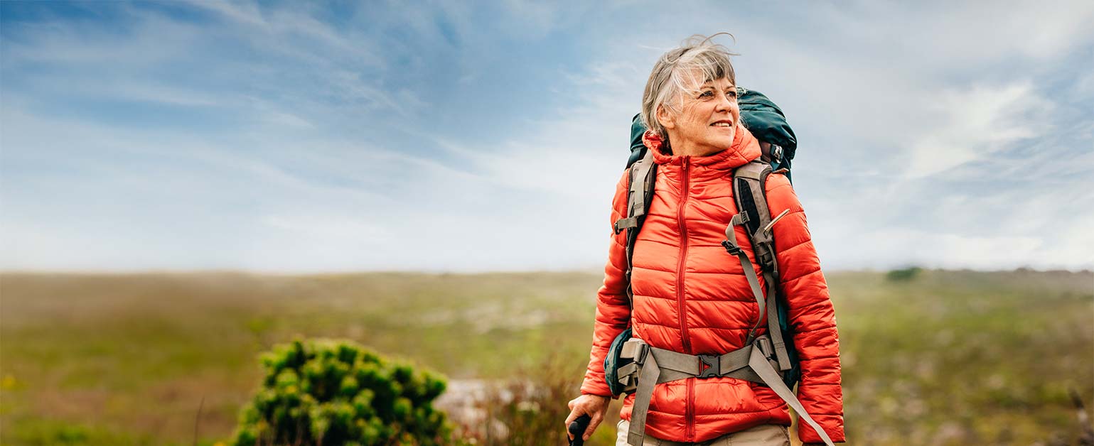 A female hiker out walking across the moors on a bright blue sky day